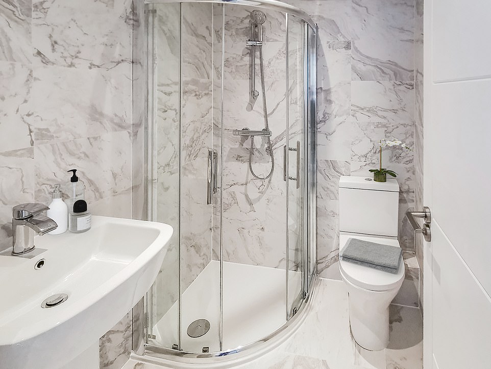 Inside the building is a stunning bathroom complete with a beautiful marble tile floor, a large curved glass shower and a heated towel rail